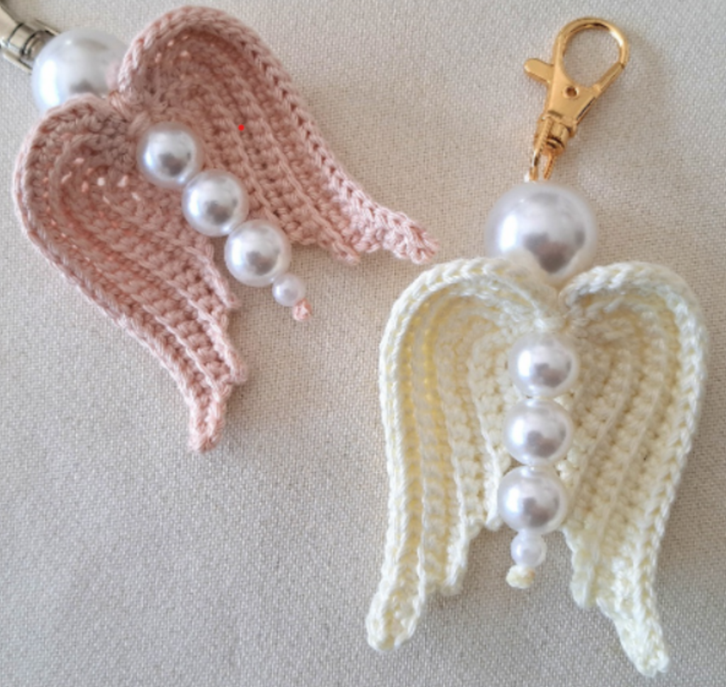 Bild von zwei Schlüsselanhängern in Form von gehäkelten Engelsflügeln mit Perlen